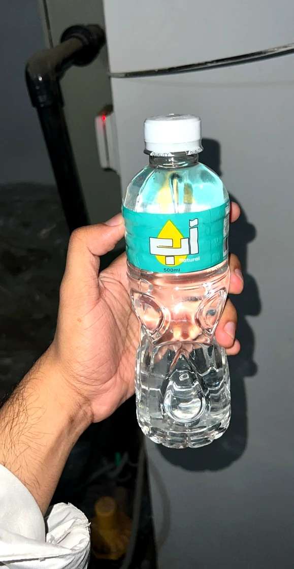 NZA Natural 500ml bottled water held in hand